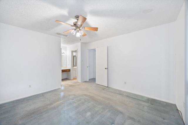 empty room with light carpet, baseboards, visible vents, ceiling fan, and a textured ceiling