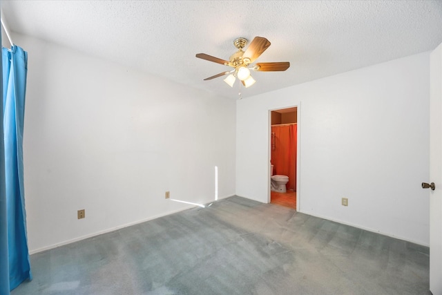 spare room with dark carpet, a textured ceiling, and ceiling fan