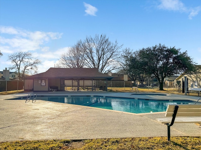 community pool featuring fence and a patio