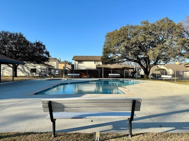 community pool with a residential view, fence, and a patio