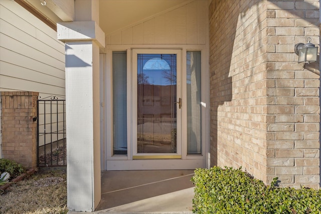 view of exterior entry with brick siding