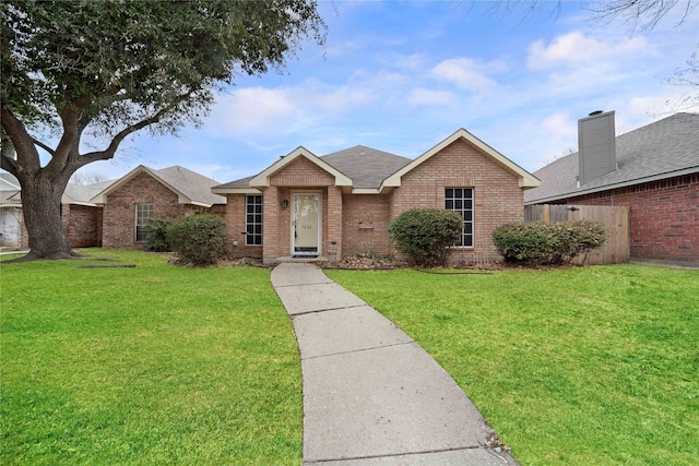 single story home featuring a front yard, brick siding, and fence