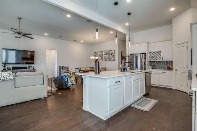 kitchen featuring open floor plan, light countertops, an island with sink, and pendant lighting