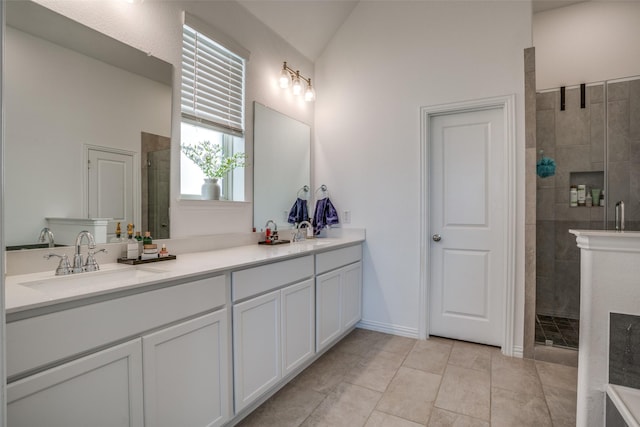 bathroom featuring a sink, a tile shower, double vanity, and vaulted ceiling