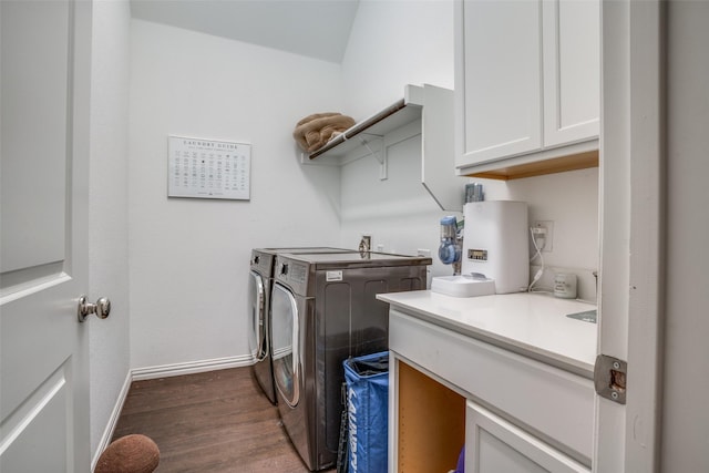 laundry room with washing machine and clothes dryer, baseboards, dark wood-style floors, and cabinet space