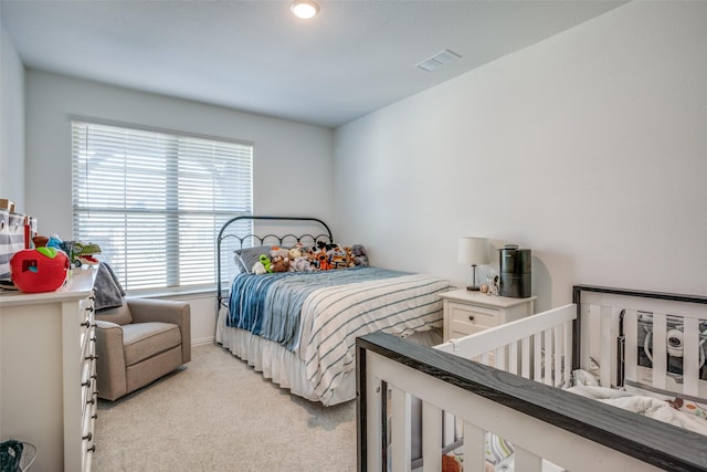 bedroom featuring visible vents and light carpet