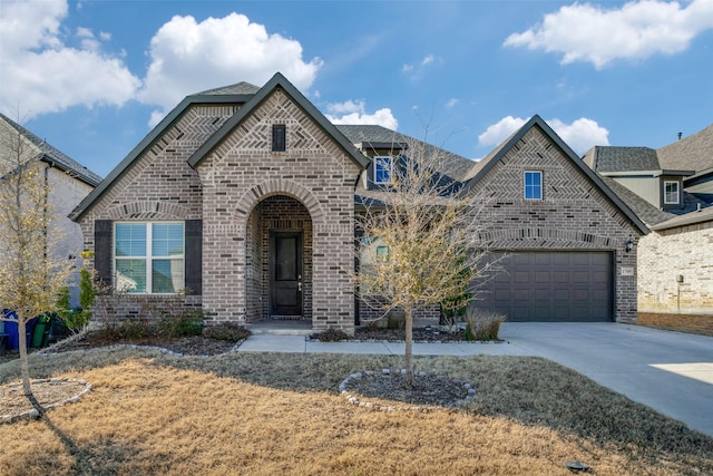 french provincial home with concrete driveway, brick siding, an attached garage, and a front yard