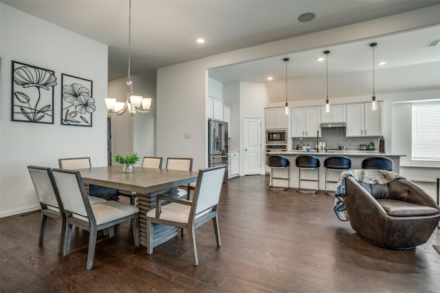 dining room with dark wood-type flooring, a notable chandelier, visible vents, and recessed lighting