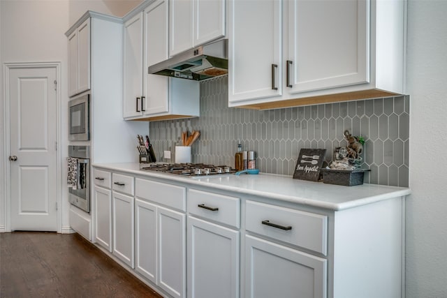kitchen featuring dark wood finished floors, tasteful backsplash, under cabinet range hood, light countertops, and stainless steel appliances