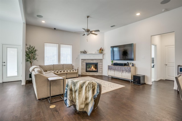 living area with visible vents, a stone fireplace, ceiling fan, dark wood finished floors, and recessed lighting
