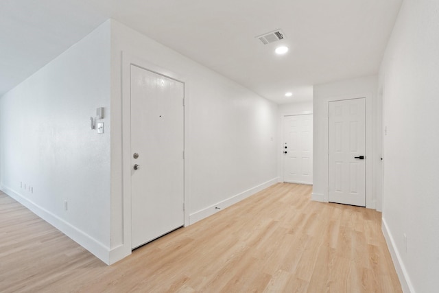 interior space with baseboards, recessed lighting, visible vents, and light wood-style floors