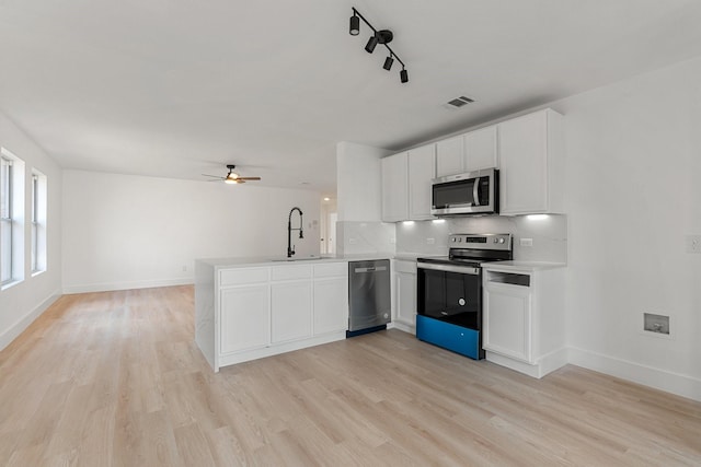 kitchen featuring stainless steel appliances, visible vents, light countertops, white cabinetry, and a peninsula