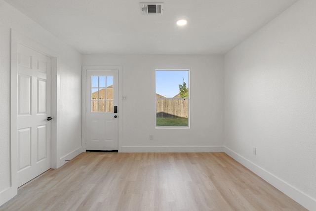 interior space with baseboards, plenty of natural light, visible vents, and light wood-style floors