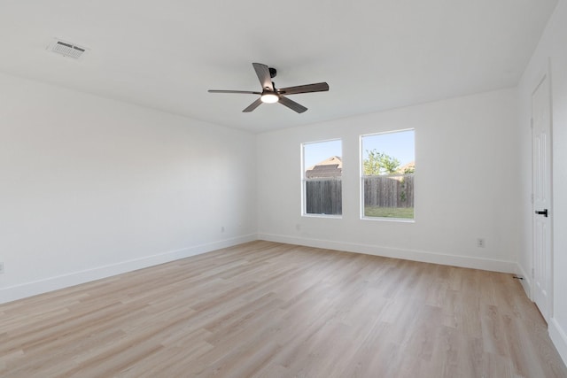 empty room with baseboards, visible vents, ceiling fan, and light wood finished floors