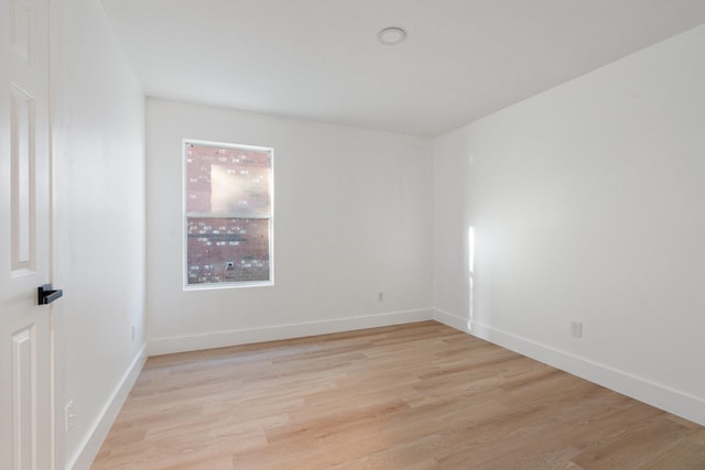 spare room featuring light wood-style flooring and baseboards