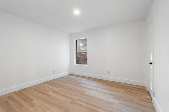 unfurnished room with light wood finished floors and baseboards