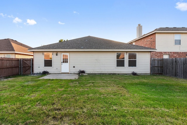 rear view of house featuring a fenced backyard, a patio, and a yard