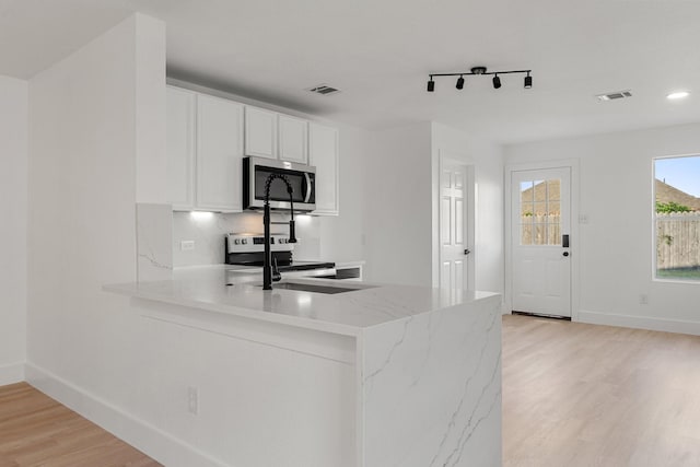 kitchen featuring light wood-type flooring, white cabinetry, visible vents, and stainless steel appliances