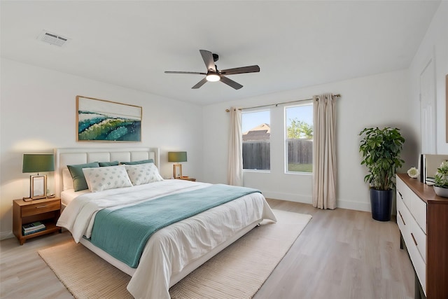 bedroom with light wood-type flooring, visible vents, ceiling fan, and baseboards