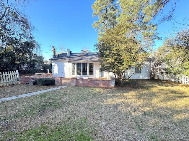 view of front of house with fence and a front lawn