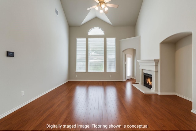11451 La Grange Dr, Frisco, TX 75035 - unfurnished living room with a ceiling fan, wood finished floors, a warm lit fireplace, lofted ceiling, and baseboards