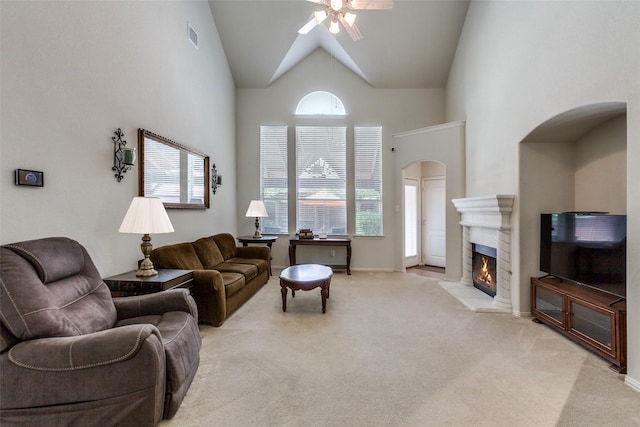11451 La Grange Dr, Frisco, TX 75035 - living area with arched walkways, ceiling fan, light carpet, a fireplace, and high vaulted ceiling