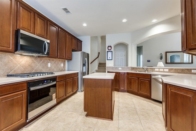 11451 La Grange Dr, Frisco, TX 75035 - kitchen featuring stainless steel appliances, a sink, a center island, light countertops, and decorative backsplash