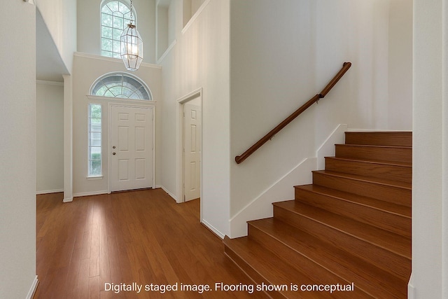 11451 La Grange Dr, Frisco, TX 75035 - foyer with plenty of natural light, a high ceiling, stairway, wood finished floors, and a chandelier