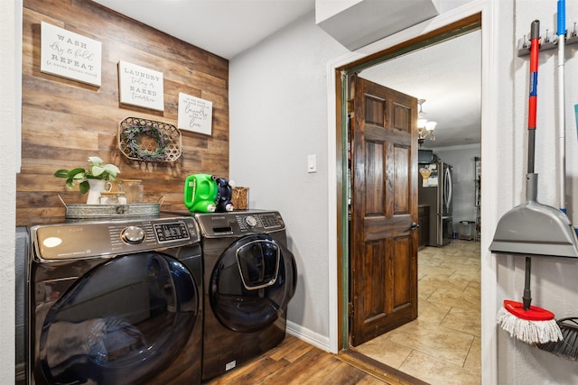 laundry room with washer and clothes dryer, ornamental molding, wooden walls, laundry area, and baseboards