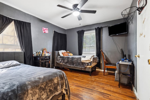 bedroom with ceiling fan, baseboards, and wood finished floors