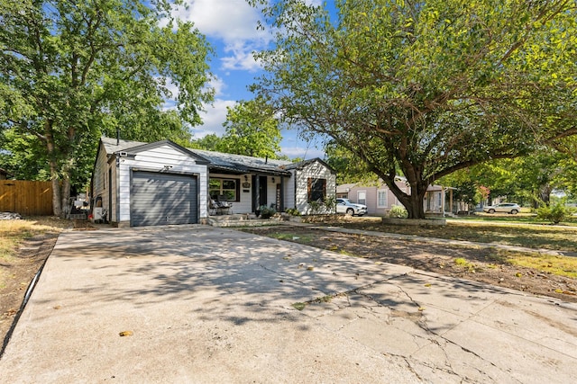 view of front of home with an attached garage, fence, and concrete driveway