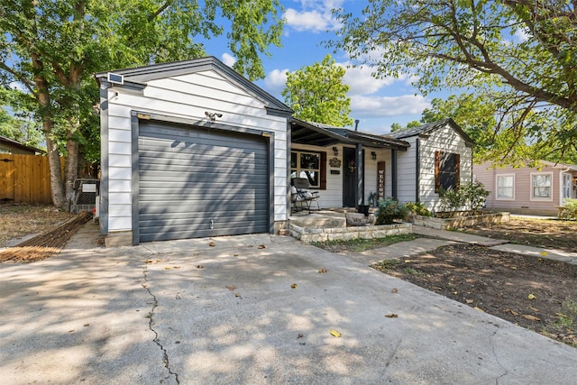 ranch-style home featuring covered porch, driveway, an attached garage, and fence