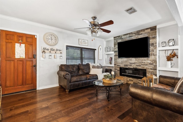 living room featuring a stone fireplace, visible vents, built in features, dark wood-style floors, and crown molding