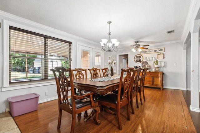 dining space featuring a chandelier, visible vents, crown molding, and wood finished floors