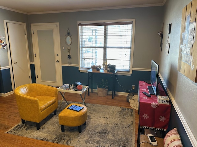 sitting room featuring crown molding, baseboards, and wood finished floors