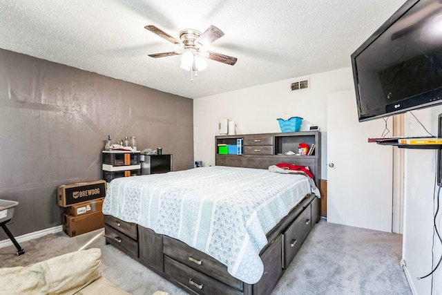 bedroom featuring a textured ceiling, a ceiling fan, visible vents, and light colored carpet