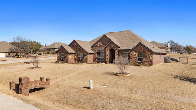 french country inspired facade featuring stone siding and fence