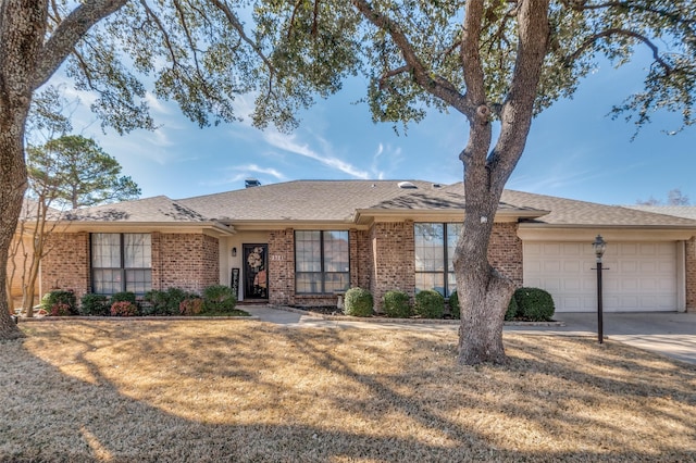 ranch-style house with brick siding, roof with shingles, a garage, driveway, and a front lawn