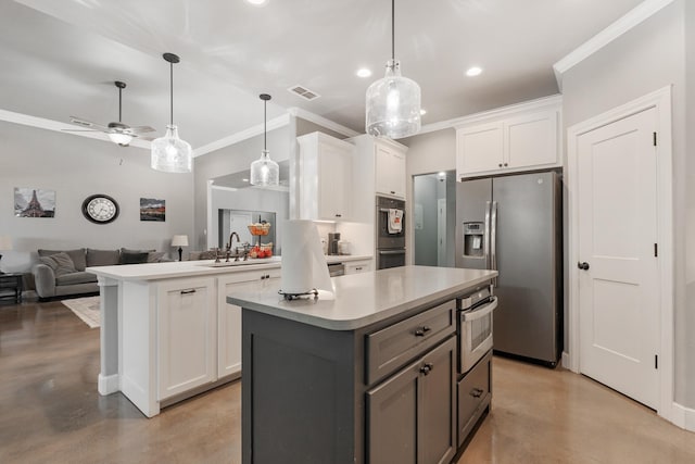 kitchen featuring stainless steel appliances, white cabinetry, open floor plan, and light countertops