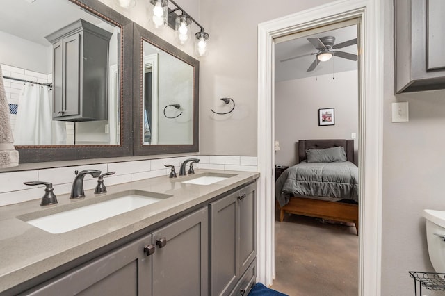 ensuite bathroom with ensuite bathroom, concrete floors, a sink, and a ceiling fan