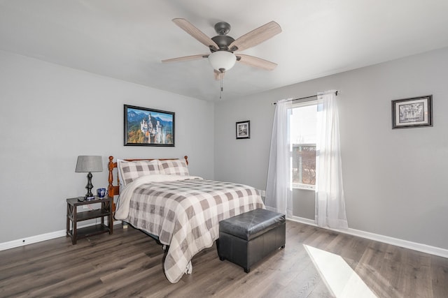 bedroom with ceiling fan, wood finished floors, and baseboards