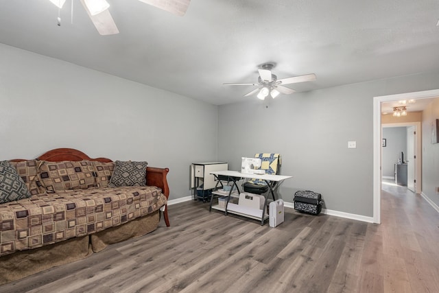 living area with ceiling fan, baseboards, and wood finished floors