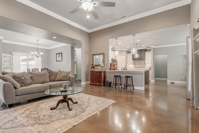 living room with crown molding, ceiling fan with notable chandelier, visible vents, and baseboards