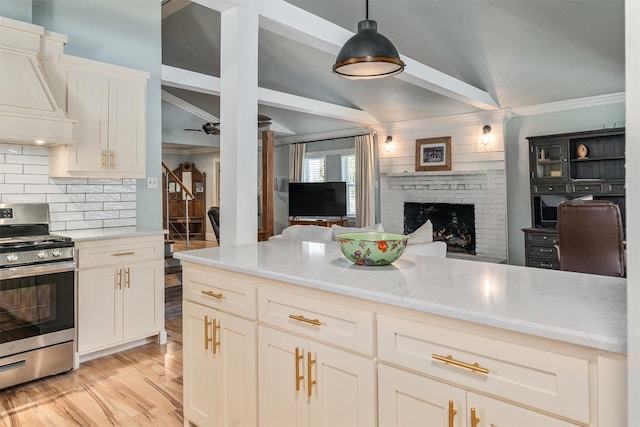 1501 Oak Shore Dr, Tool, TX 75143 - kitchen featuring custom range hood, stainless steel gas range, ornamental molding, vaulted ceiling, and a fireplace