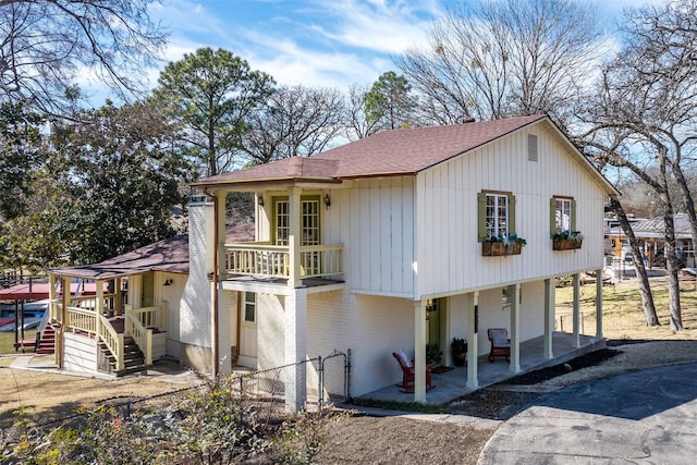 view of home's exterior with brick siding, fence, and roof with shingles