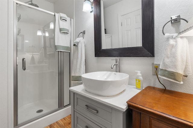 1501 Oak Shore Dr, Tool, TX 75143 - bathroom with wood finished floors, a textured wall, vanity, and a stall shower