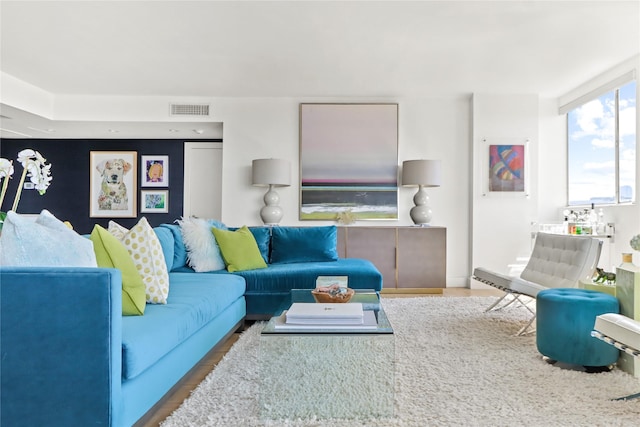 living area with visible vents and wood finished floors