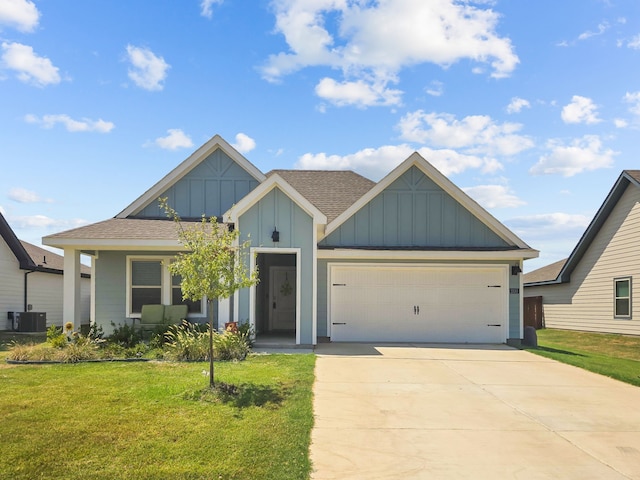 view of front of house featuring board and batten siding, a front yard, central AC, and an attached garage