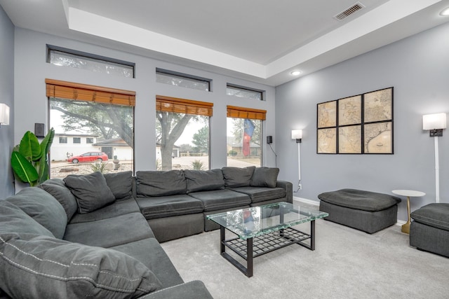 living area featuring light carpet, baseboards, visible vents, and a healthy amount of sunlight