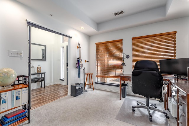 home office featuring recessed lighting, carpet flooring, visible vents, baseboards, and a raised ceiling